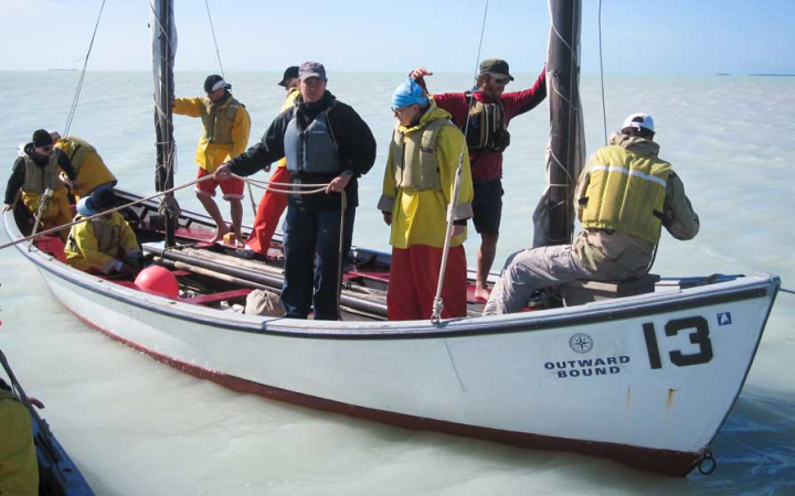 a group of veterans practice sailing techniques on an outward bound expedition 